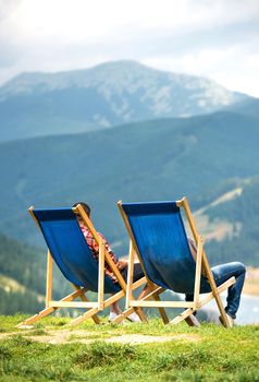 Two blue sunbeds on the top of the mountain