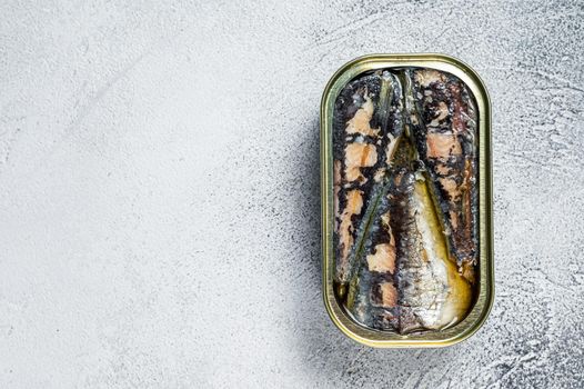 Open can with sardine in olive oil. White background. Top view. Copy space.