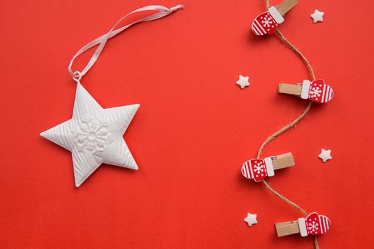 Christmas decorations decorative background. Decorative pins in the form of red gloves on a red background. Top view, minimalism, flat lay. Space for text.