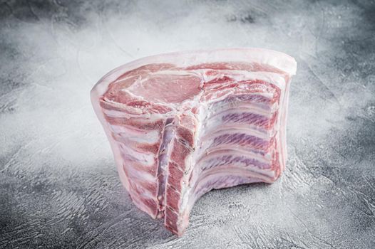 Raw whole rack of pork loin with ribs on kitchen table. White background. Top view.