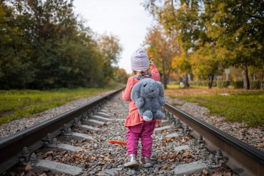 little girl walking alone on the rail road
