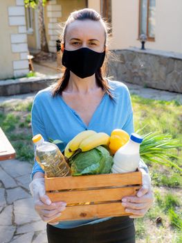 A female volunteer with a wicker basket of food for elderly people at risk during the coronavirus pandemic.