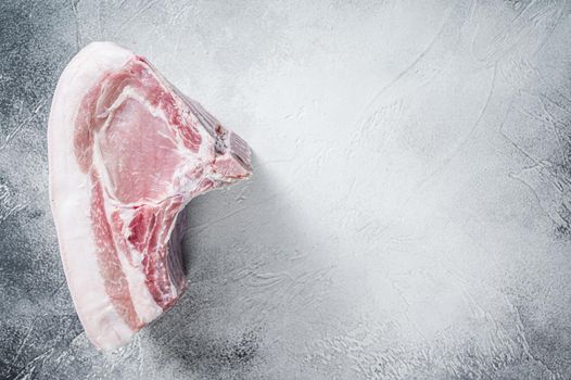 Raw whole rack of pork loin with ribs on kitchen table. White background. Top view. Copy space.