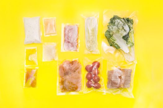 Salad dinner set: chicken, lettuce, tomatoes, peking cabbage, cheese, bacon, bread, olive oil sauces and spices. A set for delivering food for dinner on a yellow background. I cook at home. Preparing Caesar salad.