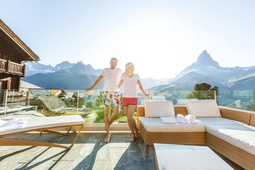 Beautiful balcony with sunbeds and plants with beautiful view of the mountains on the background and blue sky