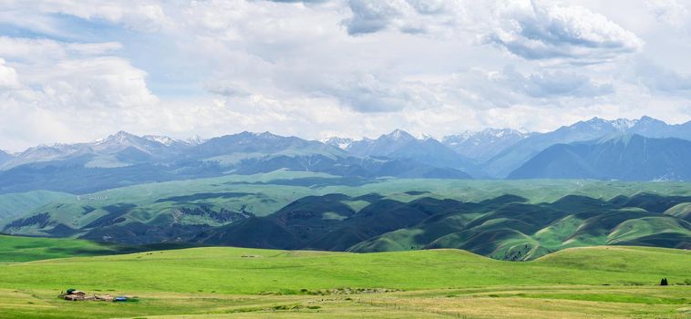 Grassland and mountains in a cloudy day. Shot in Xinjiang, China.