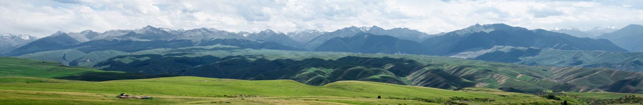 Grassland and mountains in a cloudy day. Shot in Xinjiang, China.