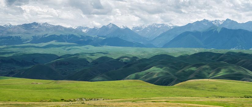 Grassland and mountains in a cloudy day. Shot in Xinjiang, China.