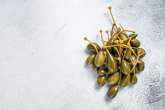 Pickled capers on a kitchen table. White background. Top view. Copy space.