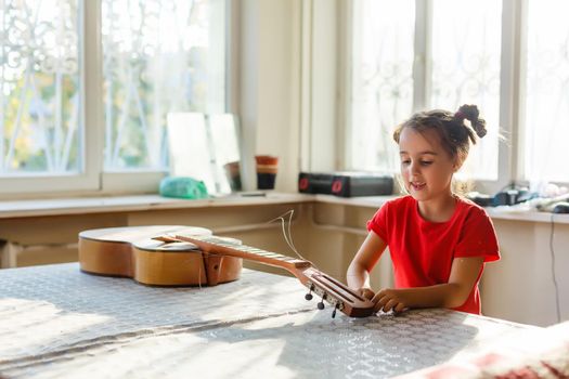 little girl holding a broken guitar, guitar repair