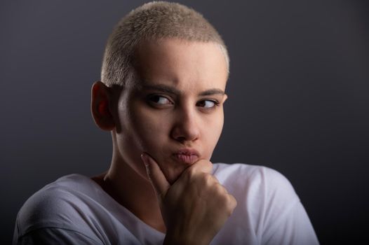 Portrait of pensive young woman with short hair on white background. Copy space.