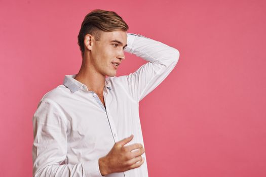 Young man in white shirt posing on pink background. High quality photo
