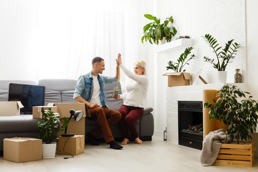 Young couple carrying big cardboard box at new home.Moving house.