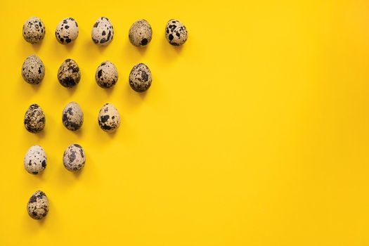 Quail Easter eggs on yellow background. Easter elements. Easter background. Easter pattern. Top view. Flat lay. Minimal concept.
