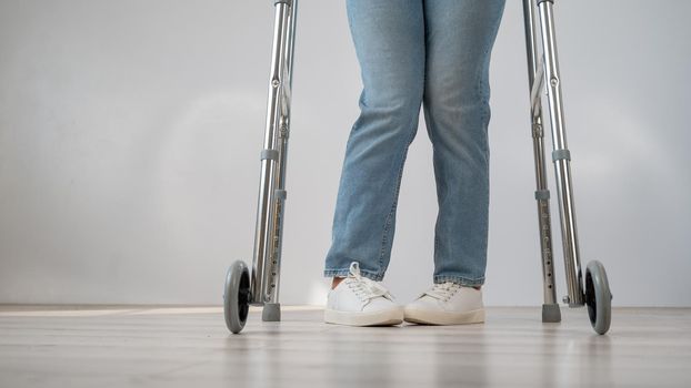 Close-up of female legs with walkers. The girl walks with the help of special equipment