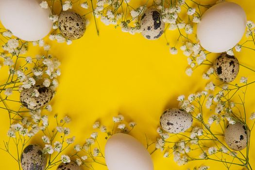 Easter background, various eggs on a yellow background, decorated with natural botanical elements, flat lay, view from above, empty space for text