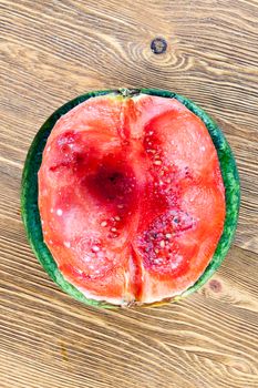 Cut into half a ripe watermelon lying on the table. on the pulp of the berries formed mold and fungus. close-up photo