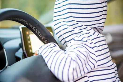 cute toddler girl driving a modern car.