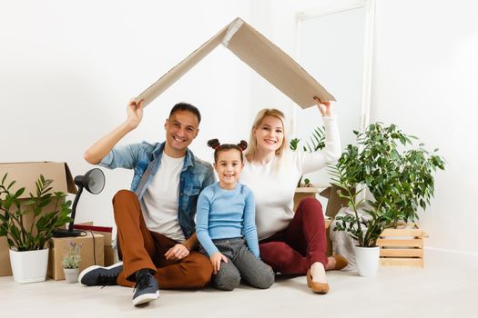 Family unpacking cardboard boxes at new home