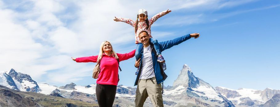 Hiking in the swiss alps with flower field and the Matterhorn peak in the background