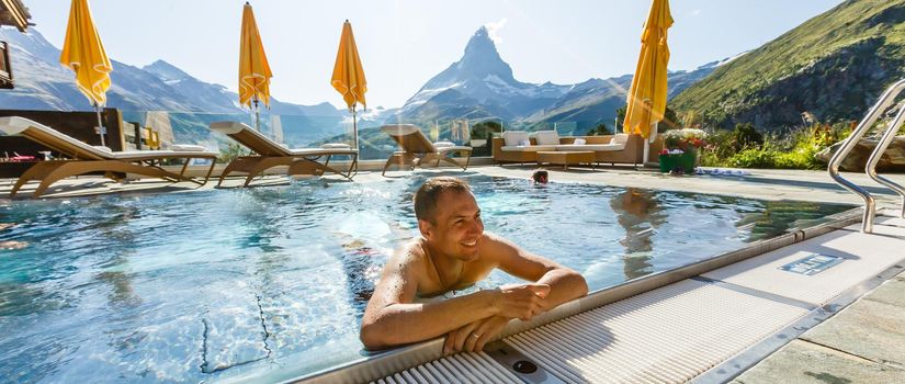 Young man chilling on a open terrace in the SPA with an amazing mountains