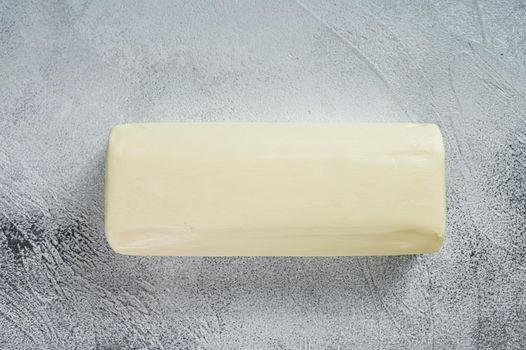 Piece of fresh butter for breakfast on kitchen table. White background. Top view.