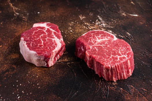 Raw Fillet Mignon tenderloin steaks. Dark background. Top view.