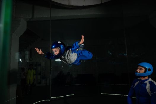 A man teaches a boy to fly in a wind tunnel