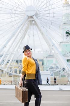 Stylish woman posing near ferris wheel