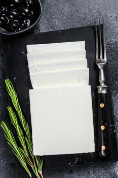 Greek cheese feta with rosemary and olives. Black background. Top view.