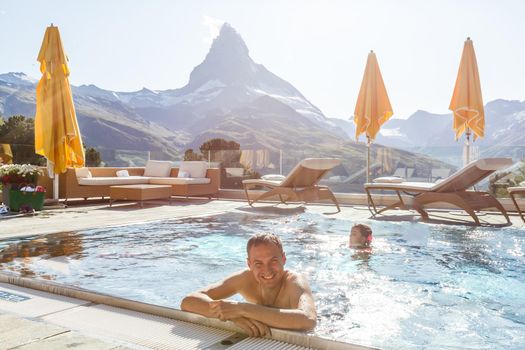 Young man chilling on a open terrace in the SPA with an amazing mountains