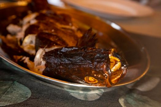 delicious smoked fish on a plate. close-up, selective focus, blurred background. dinner at reasaurant