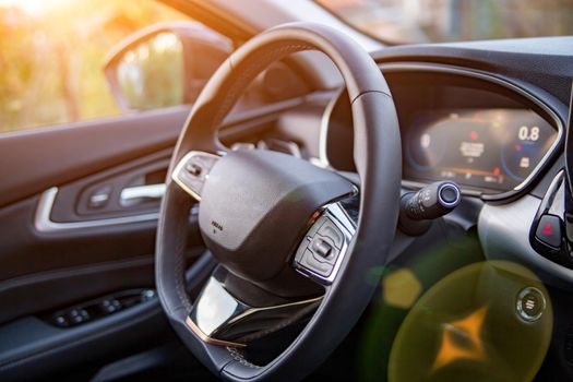 empty interior of modern premium car dark interior close-up steering wheel and driver seat