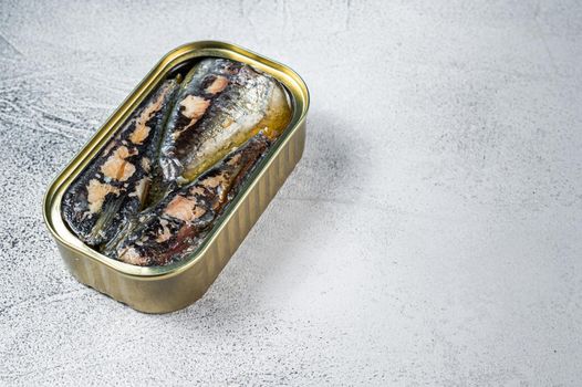 Open can with sardine in olive oil. White background. Top view. Copy space.