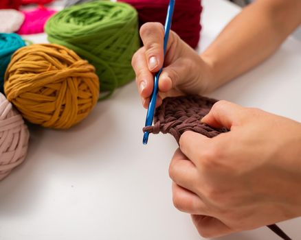 Close-up of a woman crocheting a basket of cotton yarn