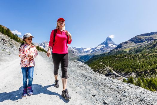 Hiking - hiker woman on trek with backpack living healthy active lifestyle. Hiker girl walking on hike in mountain nature landscape in Swiss alps, Switzerland