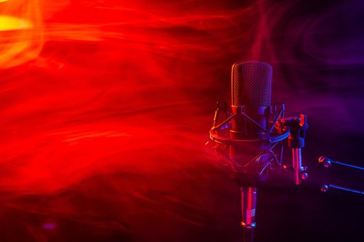 Professional microphone in red smoke on a black background