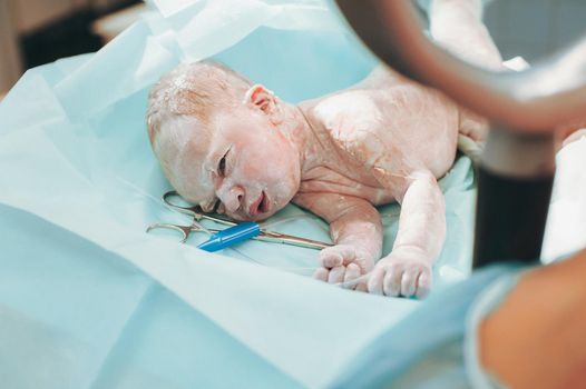 Mom and newborn baby skin to the skin after birth in the hospital