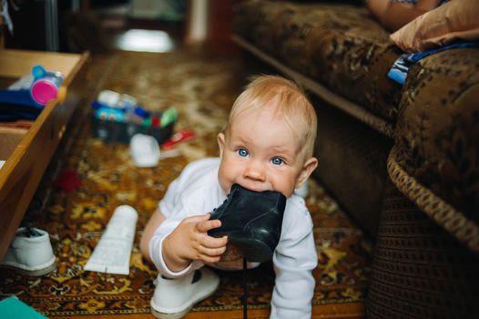Infant Baby Child Boy Six Months Old is Takes his Shoe in the Mouth