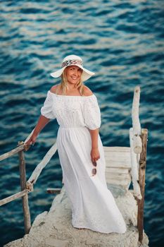 Smiling Beautiful Woman on the Beach In a Straw Hat on the island of Zakynthos.A girl in a white dress at sunset on Zakynthos island, Greece