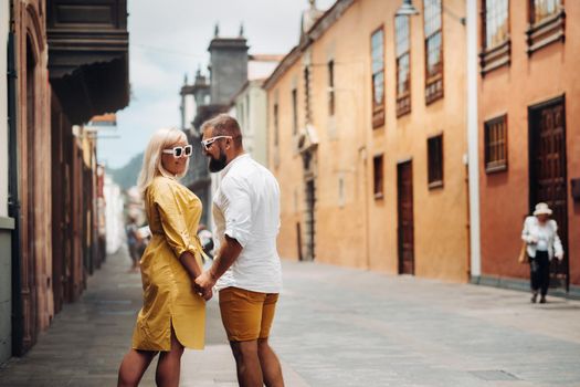 a modern married couple of lovers strolling in the old town of the island of Tenerife, a couple of lovers in the city of LA Laguna.