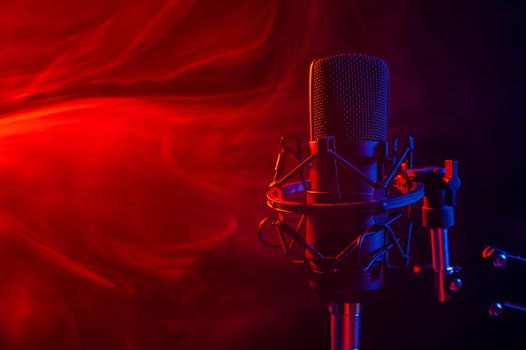 Professional microphone in red smoke on a black background