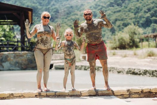 A happy family of three takes mud baths at a resort in Turkey.Family Wellness in therapeutic mud.Turkey.