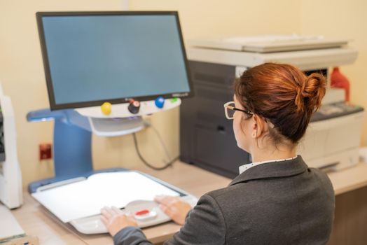 A visually impaired woman uses special reading equipment.