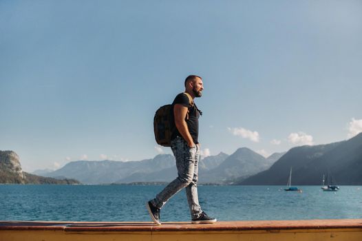 Male traveler with a backpack on the background of Alpine mountains and lakes. Vacation in the Alps.Austria.