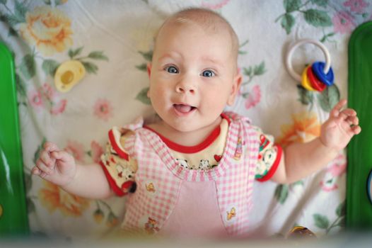 Charming little girl smiles and plays with toys