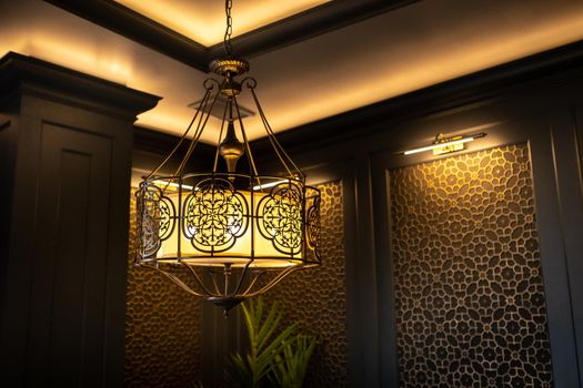 metal lamp in oriental style on the ceiling of the interior.