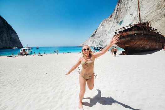 Woman relaxing on the famous Shipwreck Navagio beach in Zakynthos Greece.