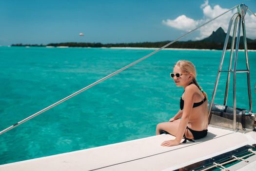 a little girl sits on a catamaran in the Indian ocean. portrait of a girl on a boat in the coral reef of the island of Mauritius.