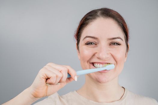 Close-up portrait of caucasian woman brushing her teeth. The girl performs the morning oral hygiene procedure.